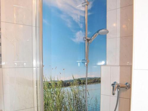 a shower in a bathroom with a view of a river at Ferienwohnung Bruttel in Gaienhofen