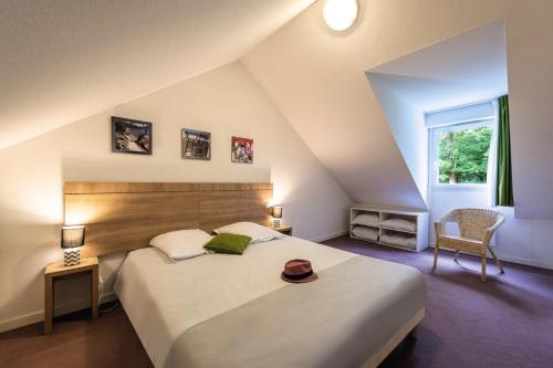 a bedroom with a large bed with a hat on it at Terres de France - Le Domaine Du Golf in Saumur