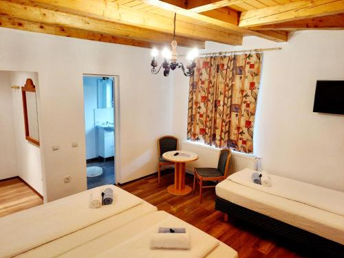 a room with two beds and a table and a window at Vila Eivissa in Porumbacu de Sus