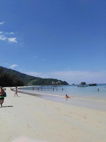 a group of people walking on the beach at Luxury Apartment at Title Residencies Naiyang Beach in Phuket Town