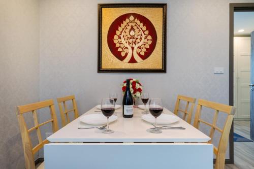a table with wine glasses and a bottle of wine at Luxury Apartment at Title Residencies Naiyang Beach in Phuket Town
