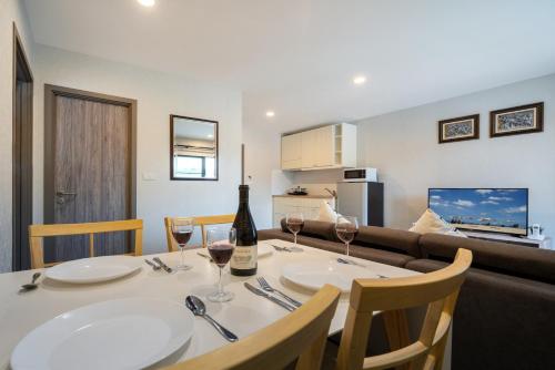 a dining room with a table with two glasses of wine at Luxury Apartment at Title Residencies Naiyang Beach in Phuket Town