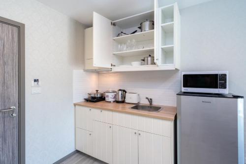 a small kitchen with a sink and a refrigerator at Luxury Apartment at Title Residencies Naiyang Beach in Phuket Town