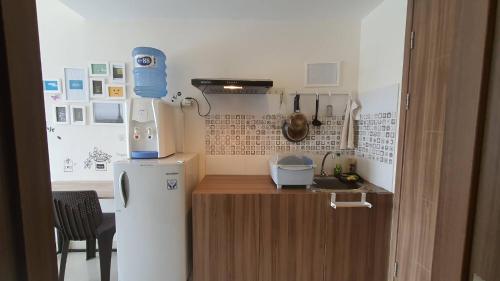 una pequeña cocina con nevera blanca y licuadora en Bacup Studio Apartment @Galeri Ciumbuleuit en Bandung