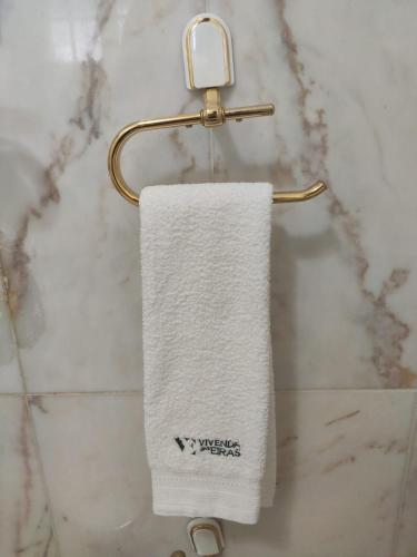 a white towel hanging on a towel rack in a bathroom at Vivenda das Eiras in Vale de Porco