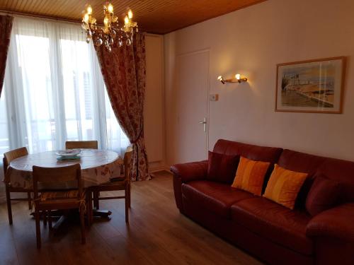un salon avec un canapé rouge et une table dans l'établissement Appartement Vue Sur Mer, à Les Sables-dʼOlonne