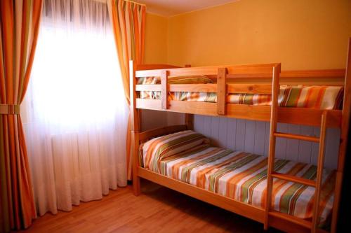 1 dormitorio con 2 literas y ventana en Casamary Planta Baja en Pontevedra