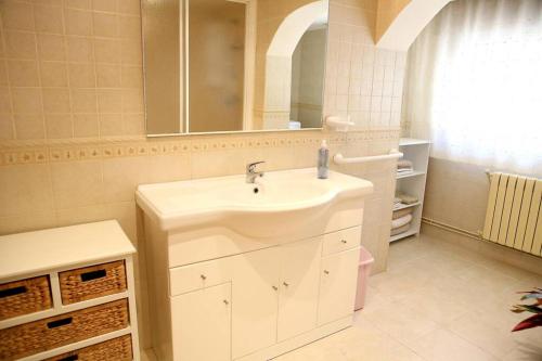 La salle de bains blanche est pourvue d'un lavabo et d'un miroir. dans l'établissement Casamary Planta Baja, à Pontevedra