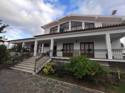 a white house with a staircase in front of it at Vivenda das Eiras in Vale de Porco
