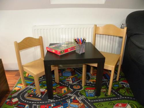 a table with two chairs and a table with a train rug at Apartment WELLNESS Vlčková in Vlčková