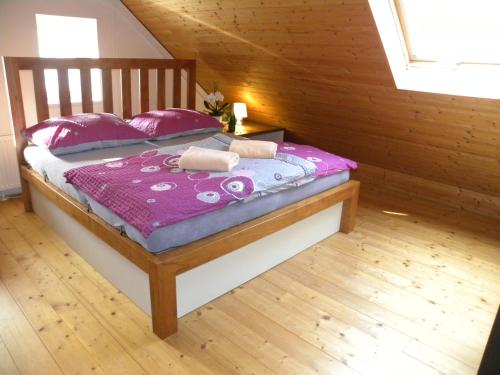 a bedroom with a bed with pink sheets and pillows at Apartment WELLNESS Vlčková in Vlčková