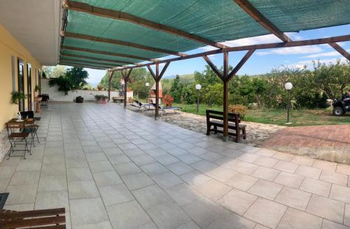 a patio with a green roof with chairs and tables at casa nostra in Ceraso