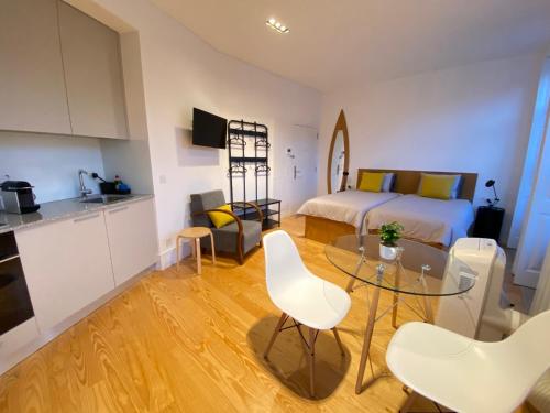 um quarto com uma cama, uma mesa de vidro e cadeiras em Porto.Leça - Studios and Apts (Apt D) em Leça da Palmeira