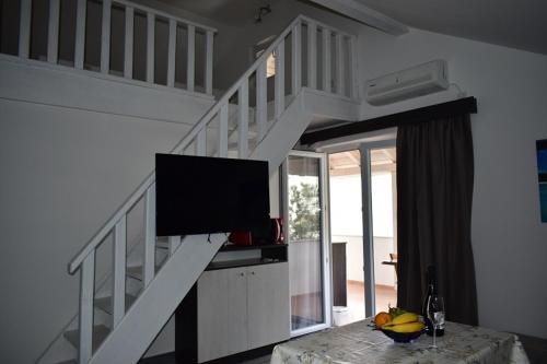 - un salon avec un escalier et une télévision à écran plat dans l'établissement VILLA LAURA, à Grebaštica