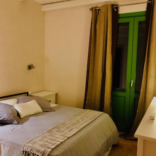 a bedroom with a bed and a green door at Case Graffeo in Menfi