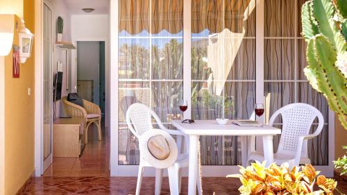 una sala da pranzo con tavolo, sedie e finestra di Apartamentos Loma Estrella a Mogán