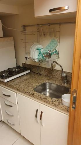 um balcão de cozinha com um lavatório e um fogão em Life Resort em Brasília