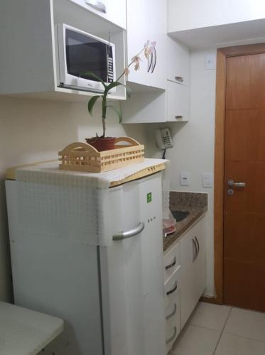 a kitchen with a white refrigerator and a microwave at Life Resort in Brasília