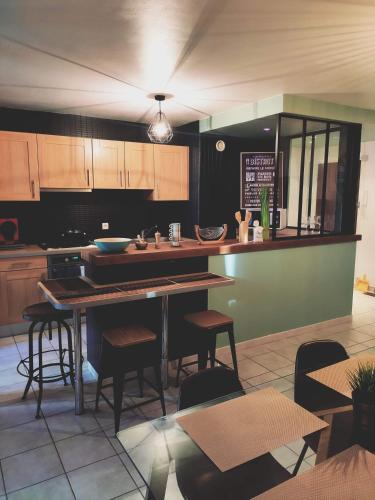 une cuisine avec des armoires en bois et une table et des chaises dans l'établissement Spacieux appartement atypique, à Brest