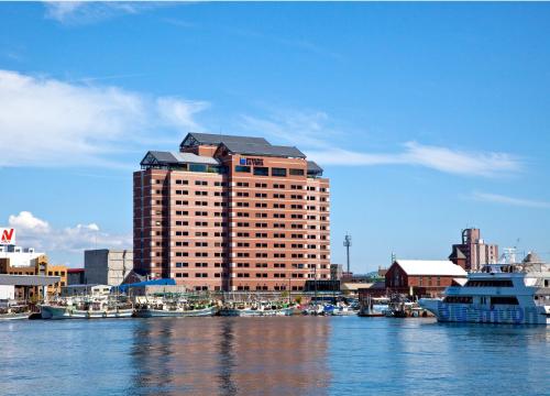 a large building with boats docked in a harbor at La Vista Hakodate Bay in Hakodate