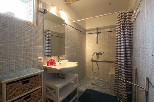 La salle de bains est pourvue d'un lavabo et d'une douche. dans l'établissement La chaumière, à Heuland