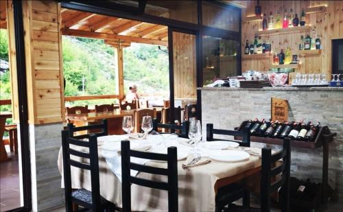 jadalnia ze stołem z krzesłami i butelkami wina w obiekcie Bar Restaurant Hotel ''Te Gusti'' w mieście Tamarë