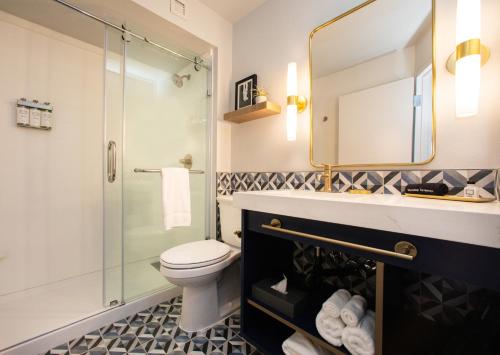 a bathroom with a toilet and a glass shower at Hotel Denim in Greensboro