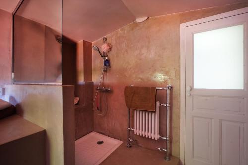 La salle de bains est pourvue d'une douche et d'une serviette murale. dans l'établissement Maison du Loup, à Ganges
