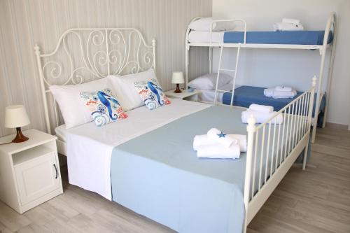 una camera con 2 letti a castello e asciugamani di Residence La Perla Marzamemi a Pachino
