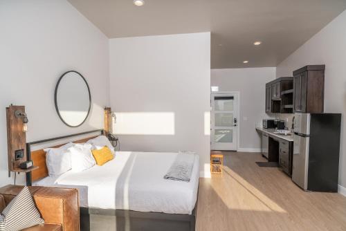 a bedroom with a white bed and a mirror at The Dwellings in La Verkin