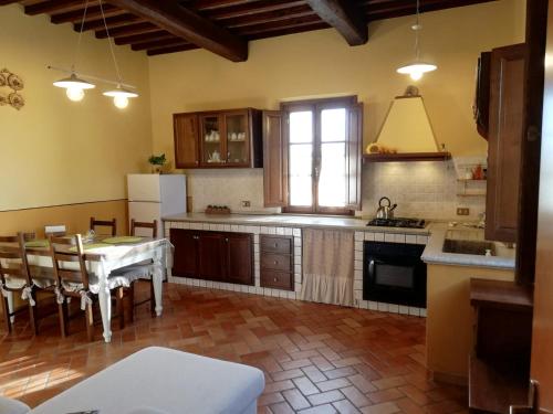 a kitchen with a table and a dining room at L'Aia degli olivi in Vada