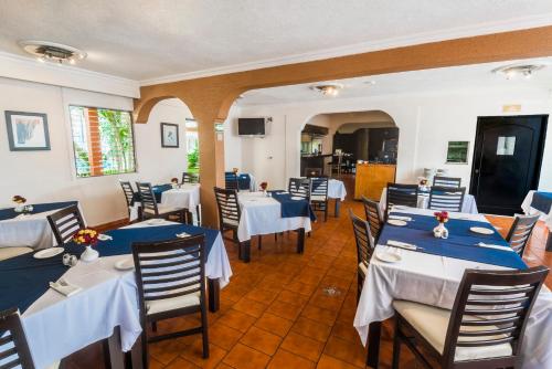 a restaurant with blue and white tables and chairs at Hotel Puerta Del Sol Guadalajara in Guadalajara