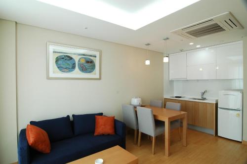 a living room with a couch and a table and a kitchen at Keumho Jeju Resort in Seogwipo
