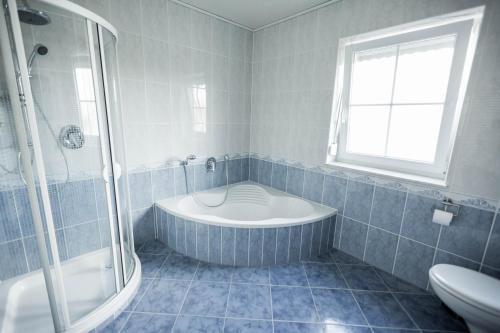 a bathroom with a tub and a shower and a toilet at Ferienwohnung Nallenblick in Gersfeld