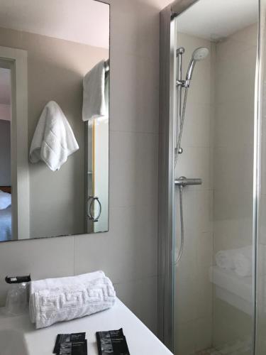 W łazience znajduje się prysznic, umywalka i lustro. w obiekcie Hostal Can Pou w mieście Vidreres