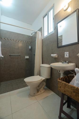 a bathroom with a toilet and a sink and a shower at El Rincon de Los Angeles in Colima