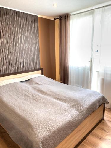 a bedroom with a bed and a large window at Apartment TT6 in Trnava