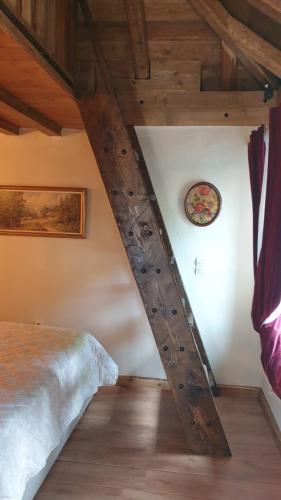 a wooden beam in a bedroom with a bed at The House in the Cobbled Road in Karpenision