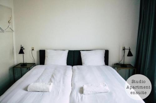 a bedroom with a large bed with two pillows at Rembrandt Square Hotel in Amsterdam