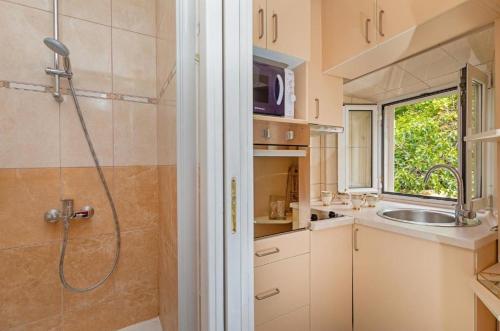 La salle de bains est pourvue d'une douche et d'un lavabo. dans l'établissement Apartman Dubrovnik, à Dubrovnik