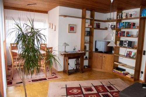 a living room with a desk and a plant at FERIENWOHNUNG im Dornröschendorf in Dörrenbach