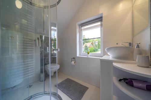 a bathroom with a glass shower and a sink at Apartament MARCEL Centrum in Szklarska Poręba