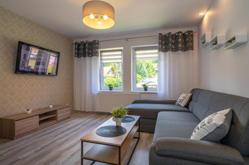 a living room with a couch and a table at Apartament MARCEL Centrum in Szklarska Poręba