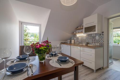 a kitchen with a table with plates and flowers on it at Apartament MARCEL Centrum in Szklarska Poręba