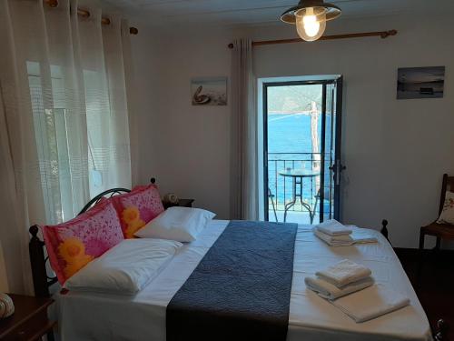 een slaapkamer met een bed en uitzicht op de oceaan bij Chiona΄s Apartments by the Sea in Palaión Trikérion