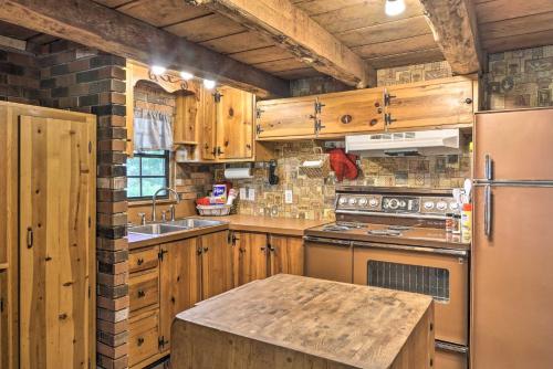 a kitchen with wooden cabinets and a stainless steel refrigerator at Peaceful Log Cabin Escape Near Table Rock Lake! in Golden