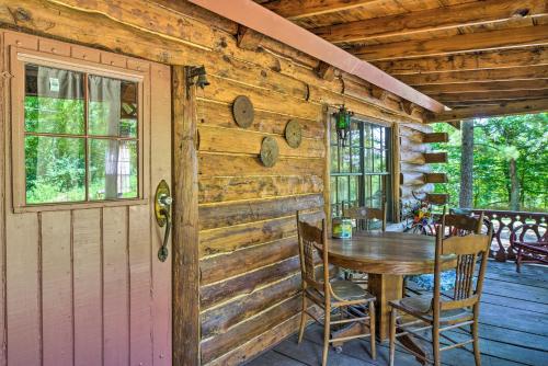 a wooden cabin with a table and chairs on a porch at Peaceful Log Cabin Escape Near Table Rock Lake! in Golden