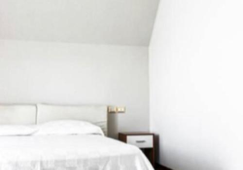 - une chambre blanche avec un lit et une table de nuit dans l'établissement La Magnolia Apartments II, à Desenzano del Garda