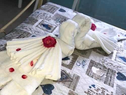 een bed met witte handdoeken en een rode roos erop bij Casa Il Gallo in Castellina Marittima