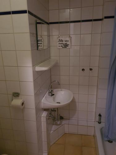 Baño blanco con lavabo y espejo en Altstadthotel Zum Goldenen Anker en Lübeck